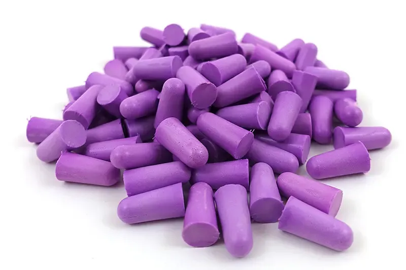 Pile of purple foam earplugs on a white background